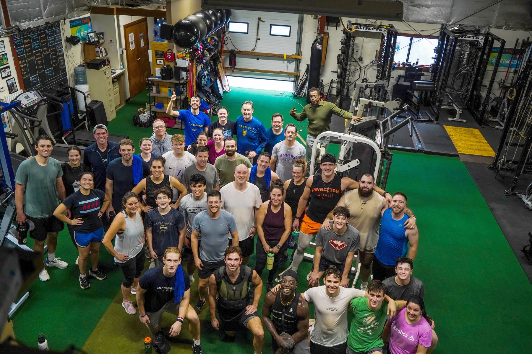 A large group of Thanksgiving bootcamp participants gathered in the gym with balloons, 2025